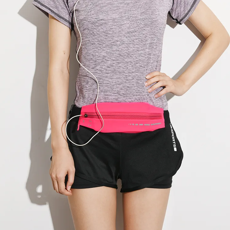 Slim running waist pack worn at the natural waist with a headphone cable routed through